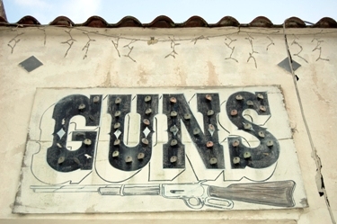Featured is a photo of a "Guns" sign still hanging on an abandoned pawn shop down Florida way by US photographer David Hartman.  Love it!