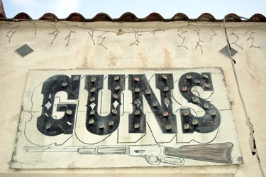 Featured is a photo of a "Guns" sign still hanging on an abandoned pawn shop down Florida way by US photographer David Hartman. Love it!
